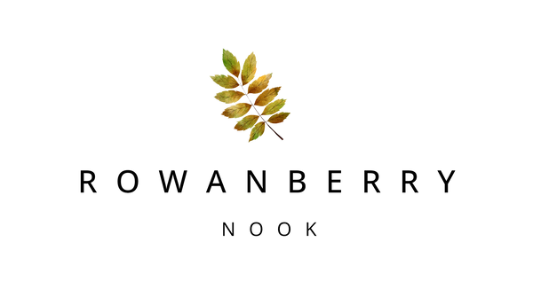 A centered brand logo on a white background featuring a small watercolor-style rowanberry leaf above the text 'ROWANBERRY NOOK' in black lettering.